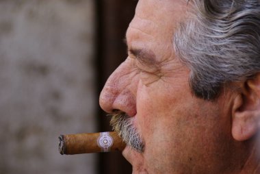 Valencia, İspanya - 13 Şubat 2019: Komuta sizde bir puro sigara bıyıklı yan portresi.