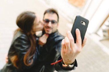 İki cep telefonu ile kendi portresi selfie yapıyor aşk içinde.