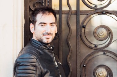 Bir kapı aralığında bir binanın bir deri ceket ile poz adam, gerçek insanlar,.