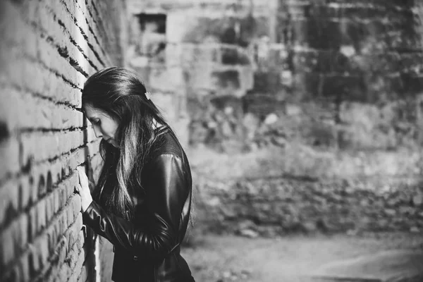 愤怒而沉思的成年年轻女子把头靠在砖墙上 反思自己的悲伤和内心的个人危机 — 图库照片