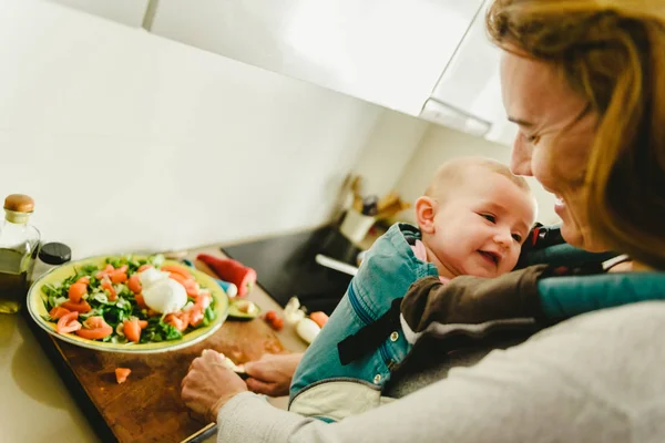 Sonriente Bebé Portado Mochila Portabebés Mirando Madre Mientras Ella Cocina — Foto de Stock