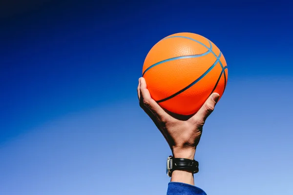 Kezében Egy Narancsszínű Kosárlabda Labda Kék Háttér Felhívás Játék Másolás — Stock Fotó