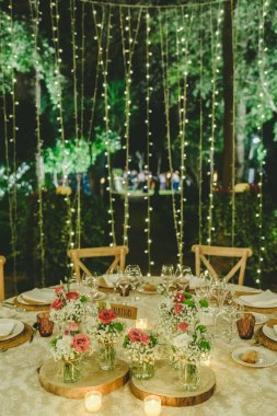 Çiçek düğün salonu tablolar üzerinde lüks çatal bıçak takımı ile centerpieces dekorasyon.