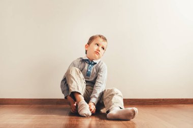 Çocuk ile lots-in çoraplarını çabaların bir ifade ile koyarak katta oturan Bağımsızlık