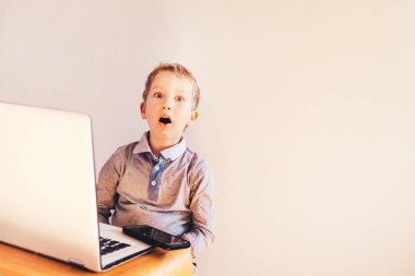 Çocuk çalışma iş sürpriz yüz ile beyaz onun laptop.