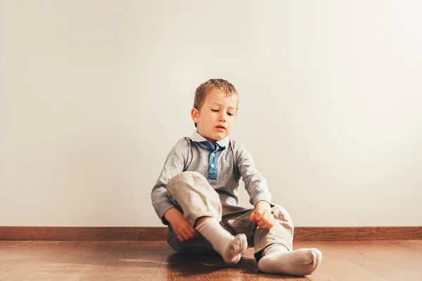 Niño Sentado Suelo Poniéndose Los Calcetines Con Una Expresión Esfuerzo — Foto de Stock