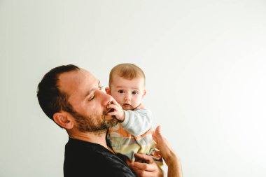 Bebek onun dokunmadan babasının kollarında yan portresi