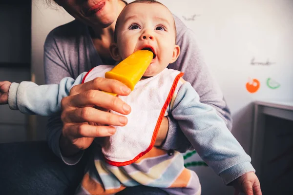 Bebé saboreando un helado de naranja . — Foto de Stock