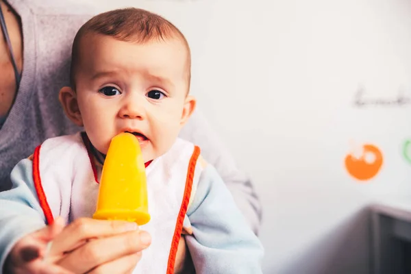 Bebé saboreando un helado de naranja . — Foto de Stock