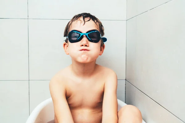 Child with sports diving goggles inside his bathtub cleaning and — Stock Photo, Image