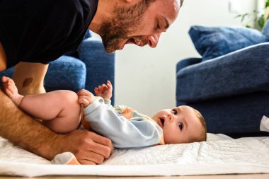 Değiştirme sırasında bebek kızı komik hareketler yapma baba