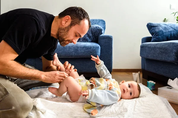 Padre cambiando el pañal de su bebé mientras lo acaricia affectiona — Foto de Stock