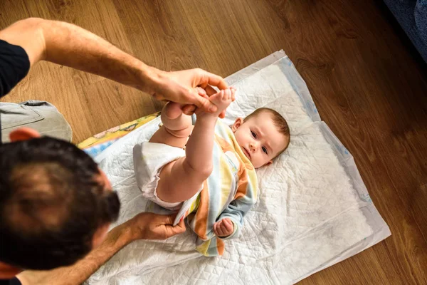 Father changing his daughter's dirty diaper. — Stock Photo, Image