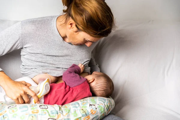 Madre amamantando a su bebé recién nacido mientras usa un breas manual —  Fotos de Stock