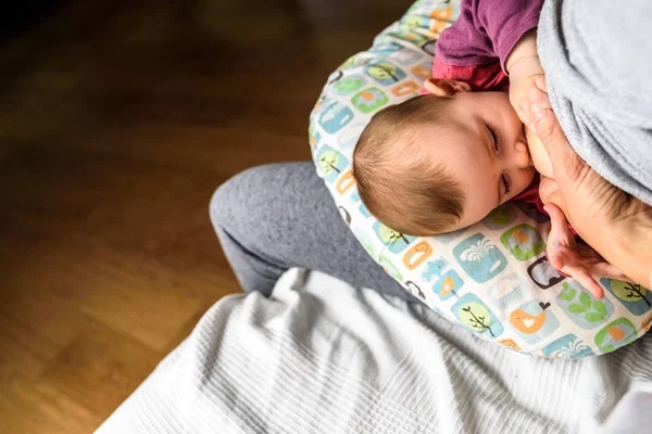 Retrato de perfil de una mujer joven amamantando a un niño usando un — Foto de Stock