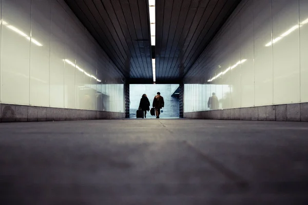 带着行李箱走过地铁地下走廊的人 — 图库照片