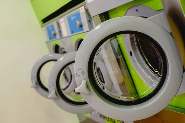 Open doors of industrial washing machines in a public laundry, d — Stock Photo, Image