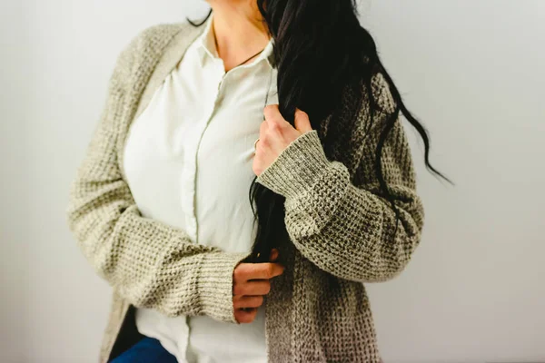 Busto de mulher morena segurando seu cabelo longo com as mãos . — Fotografia de Stock