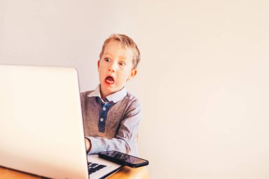 Çocuk çalışma iş sürpriz yüz ile beyaz onun laptop.