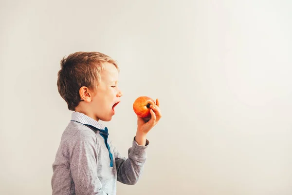 Niño listo para comer una manzana en un bocado, aislado en backgro blanco — Foto de Stock