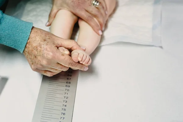 Newly born in the clinic of the pediatrician measuring a height — Stock Photo, Image