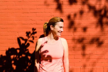 Yetişkin kadın yan spor yapmadan bakarak gülen 