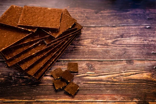 Muchas tabletas de chocolate negro gourmet aislados en el fondo de madera —  Fotos de Stock