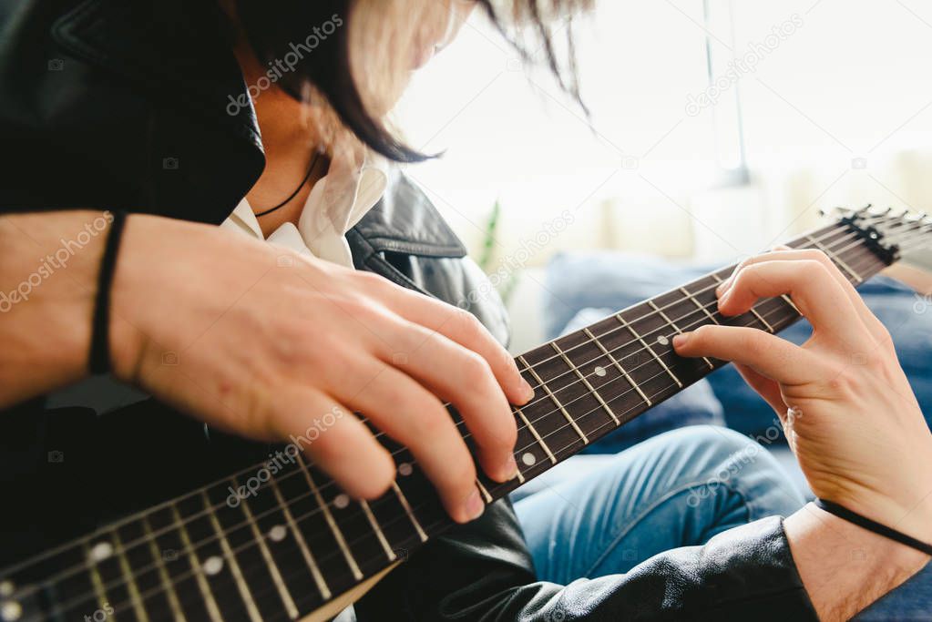 Placing the fingers on a guitar to play some notes by a professi