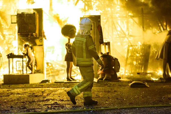 Feuerwehrmänner um ein Lagerfeuer, das von einem falla valenciana controllin verursacht wurde — Stockfoto