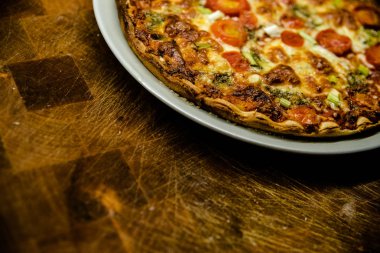 Ev yapımı pizza çanak koyu ahşap masa üzerinde kiraz domates ile