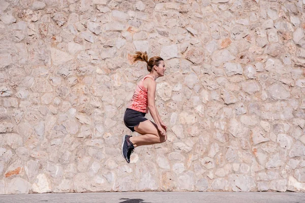 Fitness giysileri ile orta yaşlı kadın atlet egzersizleri yapıyor — Stok fotoğraf