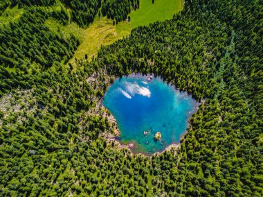 Alp Dağları arasında mavi bir gölün havadan fotoğrafı.