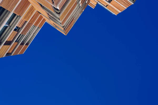 Vista desde el suelo de la fachada de un moderno edificio revestido en e — Foto de Stock