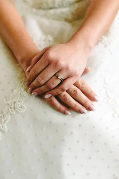 Wedding ring in the hands of a woman with her wedding dress. — Stock Photo, Image