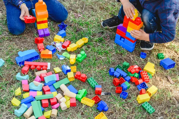 Niño jugando con bloques de colores sentado en el suelo de una ga —  Fotos de Stock