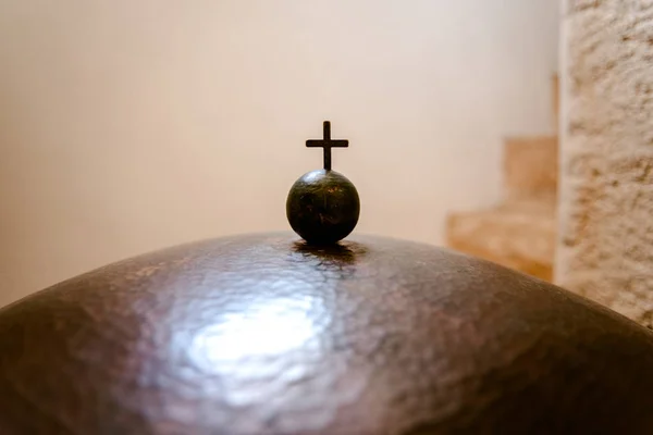 Christliches Kreuz auf einer kleinen Metallkugel, negativer Raum. — Stockfoto