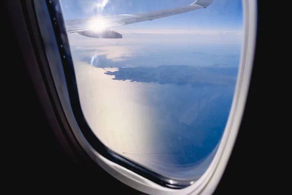 Облака и небо видны через окно самолета, самолета — стоковое фото