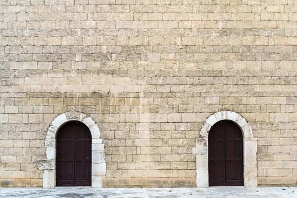 Nagy kőfalak két szimmetrikus ajtóval, középkori kőből hátul — Stock Fotó