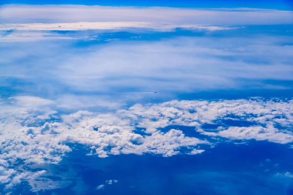 Plane of commercial flights crossing a sky of blue and white clo — Stock Photo, Image