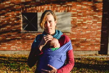 anne sevgiyle bir askı eşarp durin onu yeni doğan bebek taşıyan