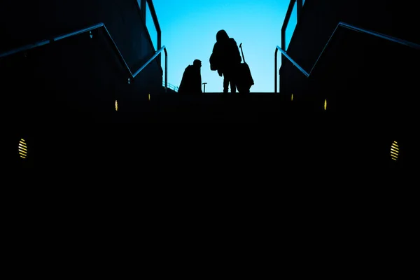 Silhouette két utas a bőröndök kocsi kúszó — Stock Fotó