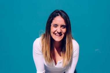 Gerçek yüzlü genç bir kadın, manken değil, yüksek sesle gülüyor.