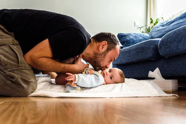Affectionate father playing with his baby while he changes the d — Stock Photo, Image