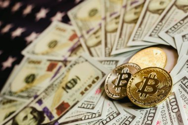 Amerikan bayrağı arka plan ile Bitcoins ve 100 dolar faturaları.