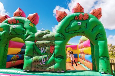 Bir çocuk playgrou dinozorlar şeklinde Bouncy kale