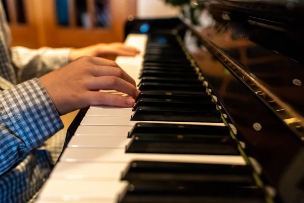 Kinderhände spielen an Weihnachten die Tasten eines Klaviers. — Stockfoto