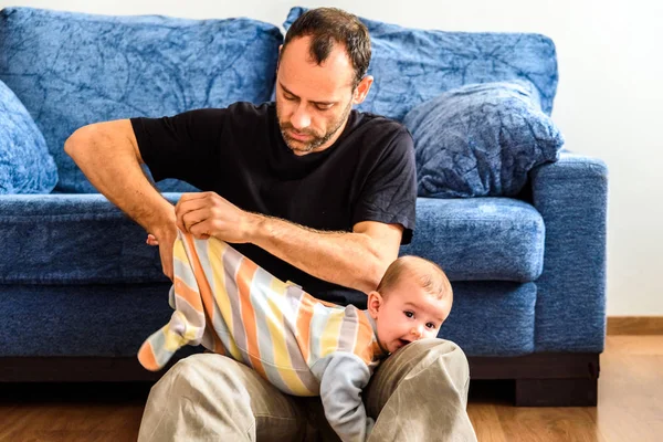 Новичок отец переодевается на своего ребенка с усилием в ли — стоковое фото