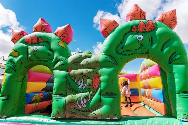 Castelo insuflável na forma de dinossauros em um playgrou infantil — Fotografia de Stock