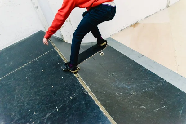 Jovem realizando acrobacias com um skate interior . — Fotografia de Stock