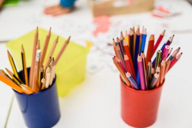 Bir anaokulunda bir çalışma masasında renkli kalemler.